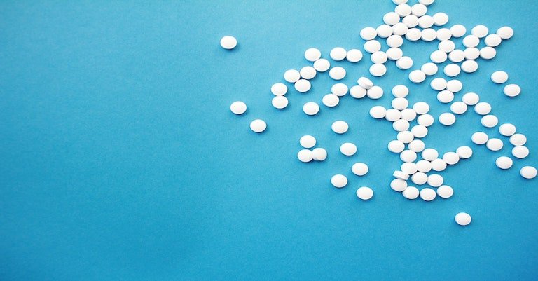Image: medicine tablets on a blue table
